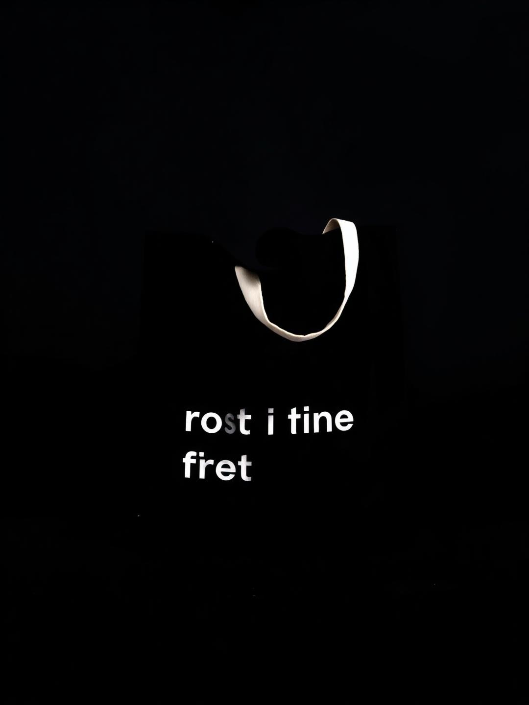 Black canvas tote bag with bold typography